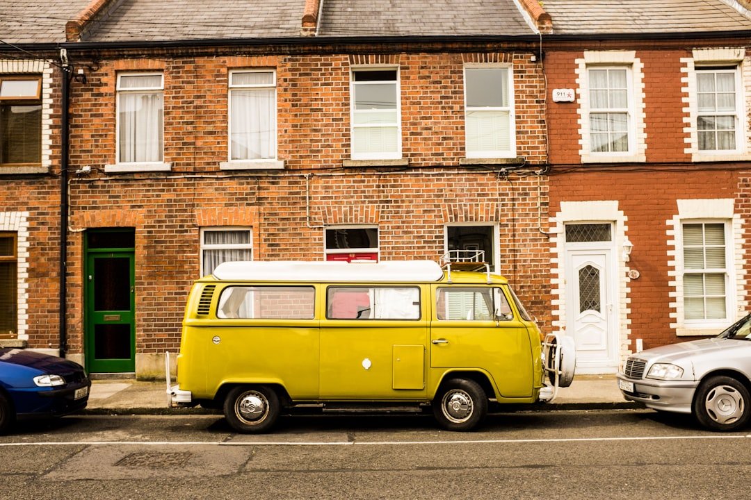a yellow van parked in front of a brick building