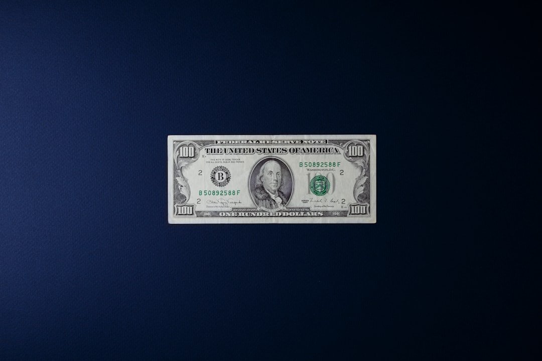 a one dollar bill sitting on top of a blue surface