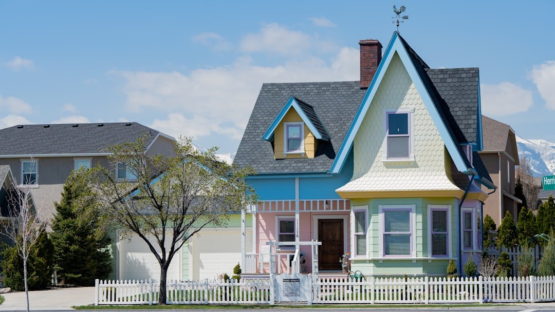 a multicolored house with a white picket fence