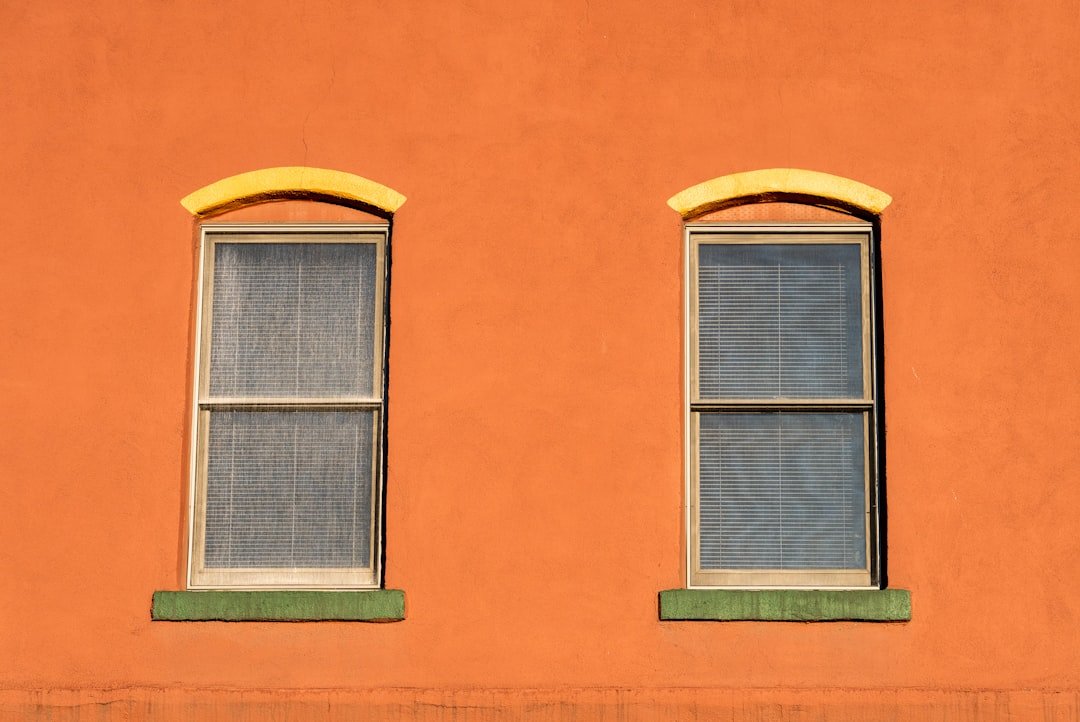 orange concrete building with green window