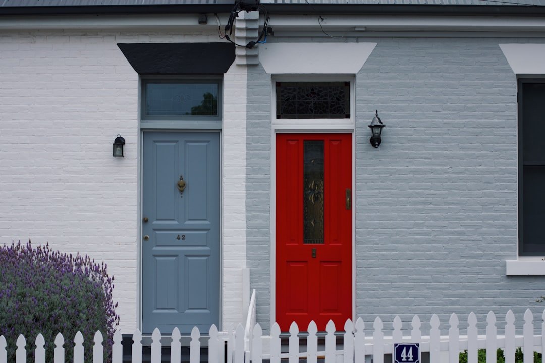 A house with a red door and a white picket fence