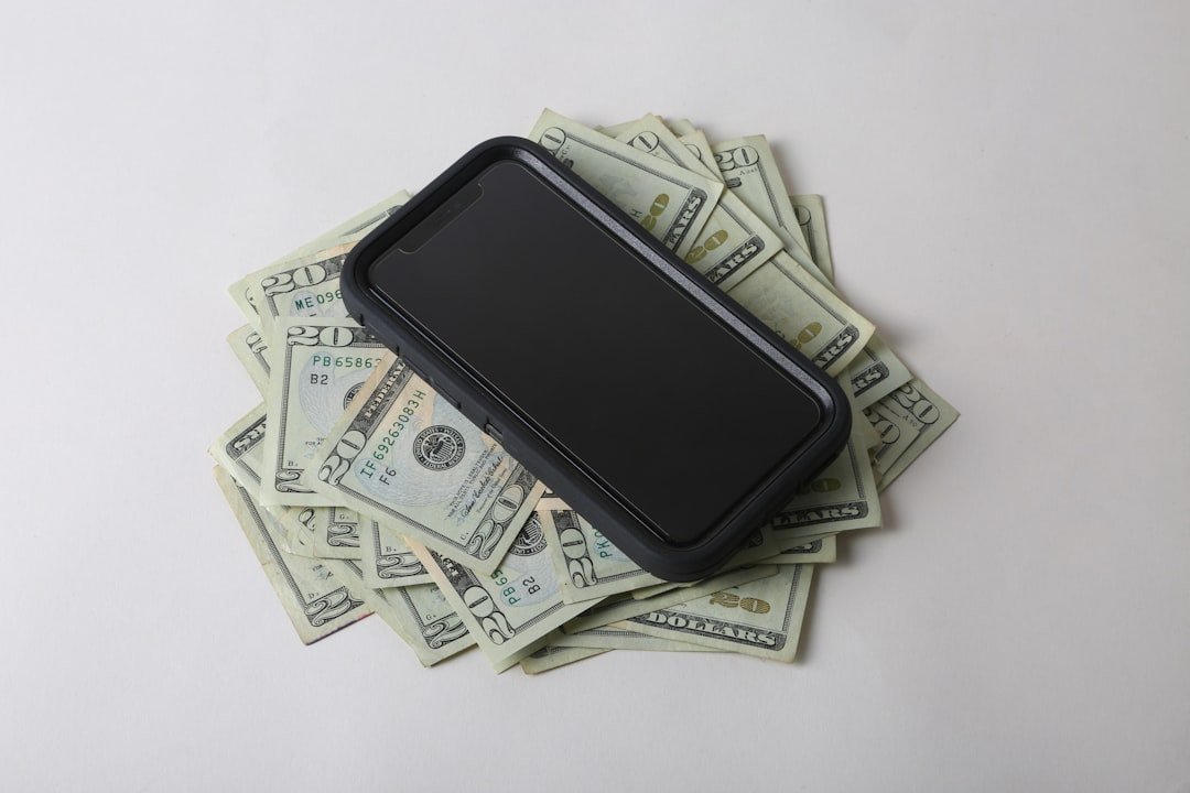 a cell phone sitting on top of a pile of money