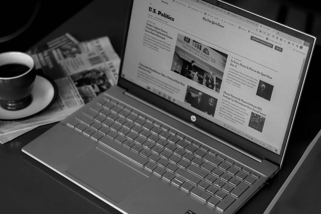 a laptop computer sitting on top of a desk next to a cup of coffee
