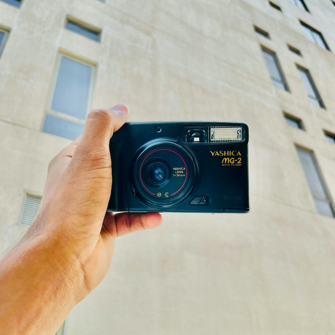 a person holding a camera in front of a building