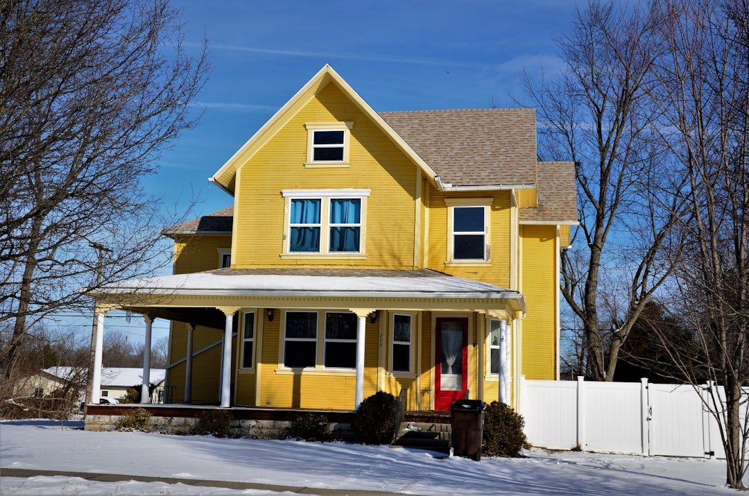 a yellow house with snow on the ground