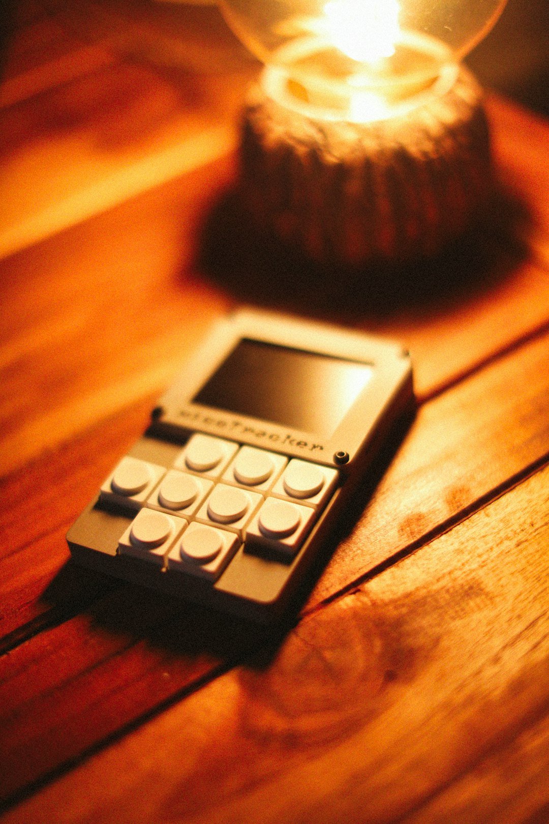 A small electronic device sits on a wooden table.