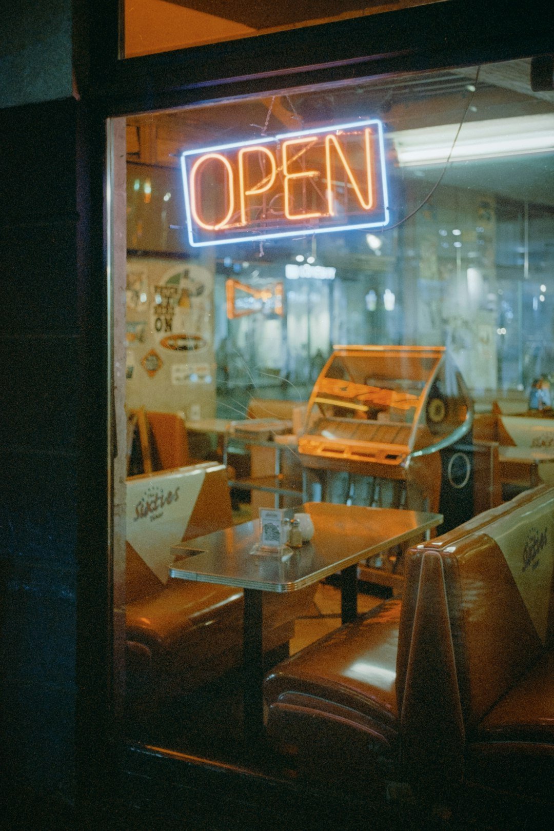 a restaurant with a neon open sign in the window