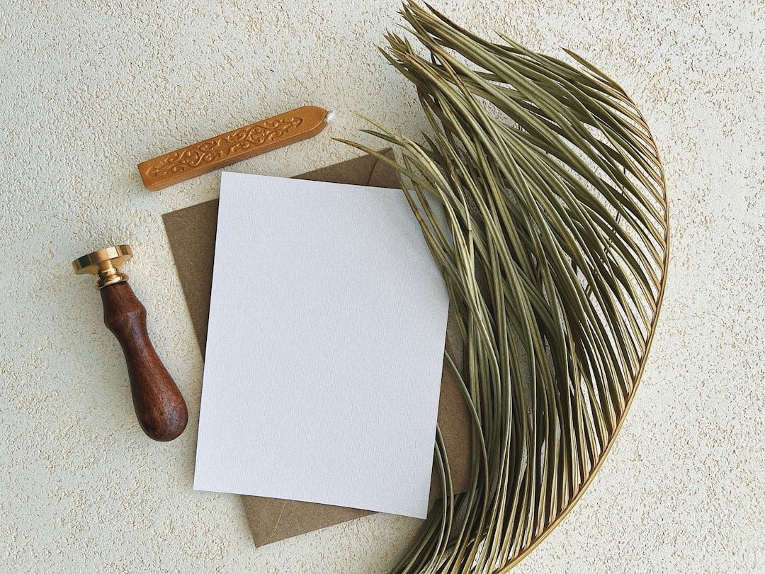 a white piece of paper with a brown handle and a wooden spoon