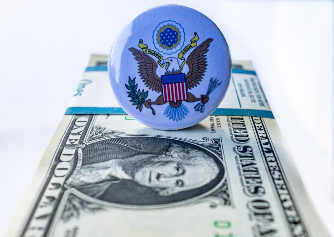 A blue button sitting on top of a one dollar bill