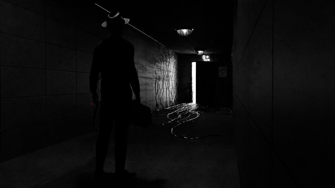 a man standing in a dark hallway with a cane in his hand
